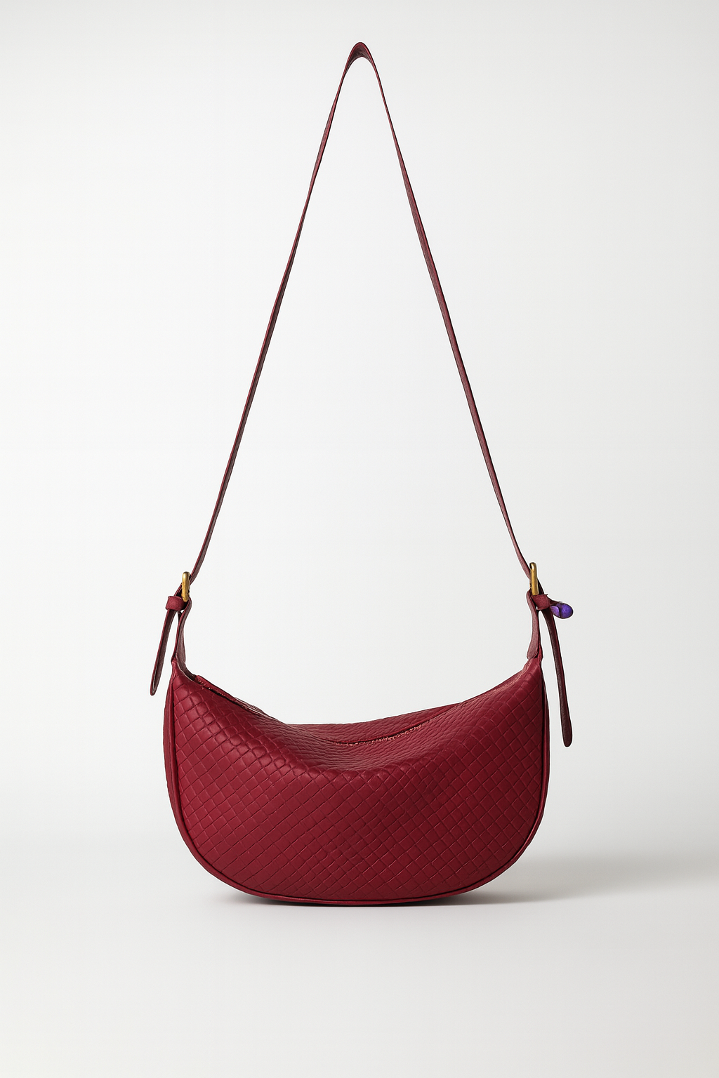 Red handbag with a strap on a white background